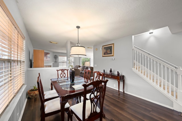 dining area with a textured ceiling and dark hardwood / wood-style floors