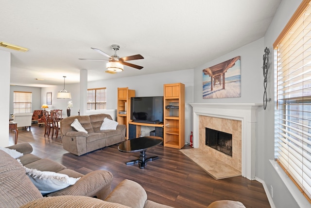 living room with ceiling fan, a fireplace, and dark hardwood / wood-style flooring