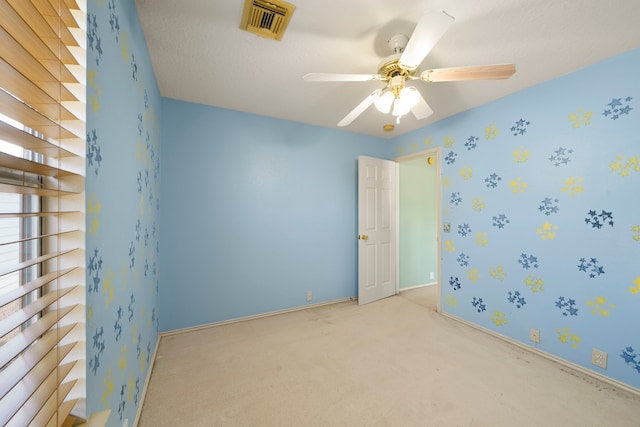 empty room featuring light colored carpet and ceiling fan