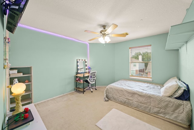 carpeted bedroom with ceiling fan and a textured ceiling