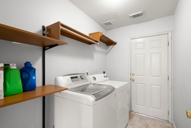 laundry room featuring a textured ceiling and separate washer and dryer