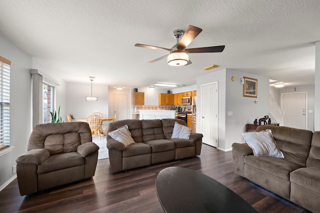 living room featuring a textured ceiling, ceiling fan, and dark hardwood / wood-style flooring