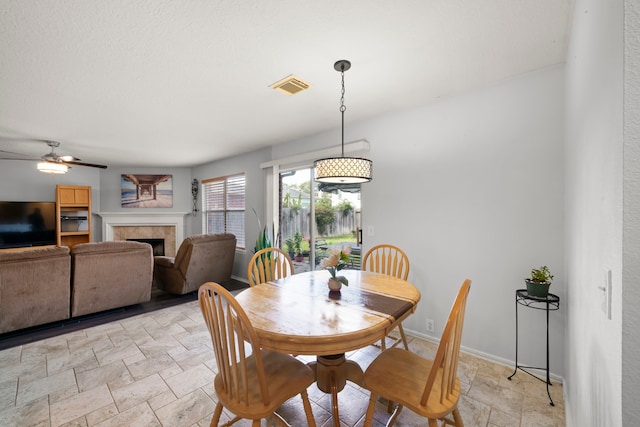 dining room featuring a fireplace and ceiling fan