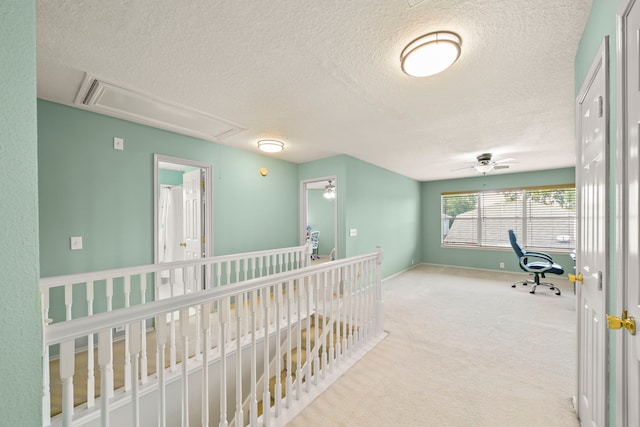 hallway featuring a textured ceiling and carpet