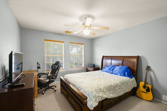 carpeted bedroom with ceiling fan and a textured ceiling