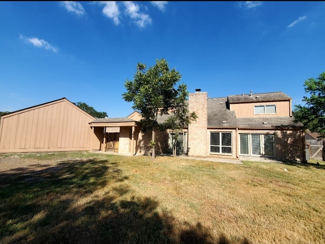 rear view of property with a yard