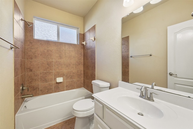 full bathroom featuring vanity, tiled shower / bath combo, and toilet