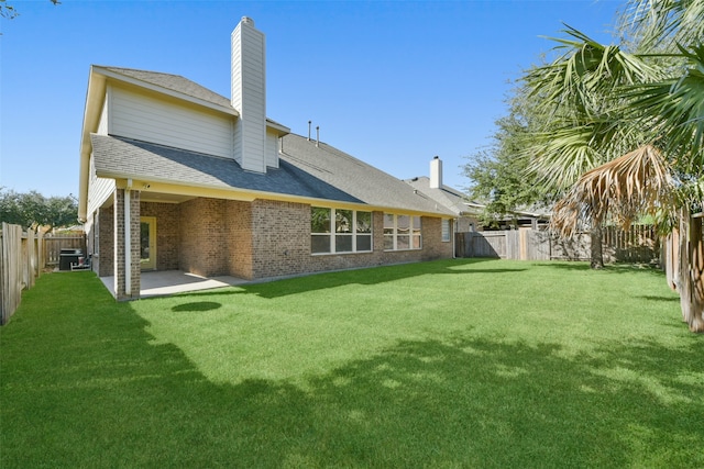 rear view of property featuring a lawn and a patio