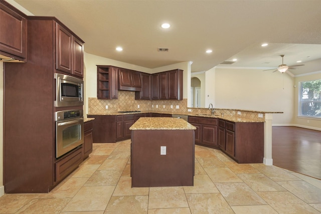 kitchen with kitchen peninsula, stainless steel appliances, crown molding, sink, and a center island