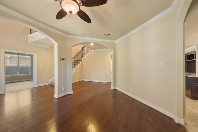 unfurnished living room featuring ceiling fan, wood-type flooring, and ornamental molding