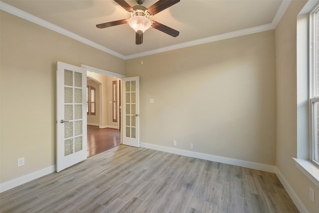 spare room featuring crown molding, french doors, and light hardwood / wood-style floors