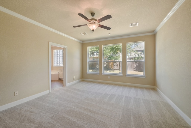 empty room with a textured ceiling, light colored carpet, ceiling fan, and crown molding