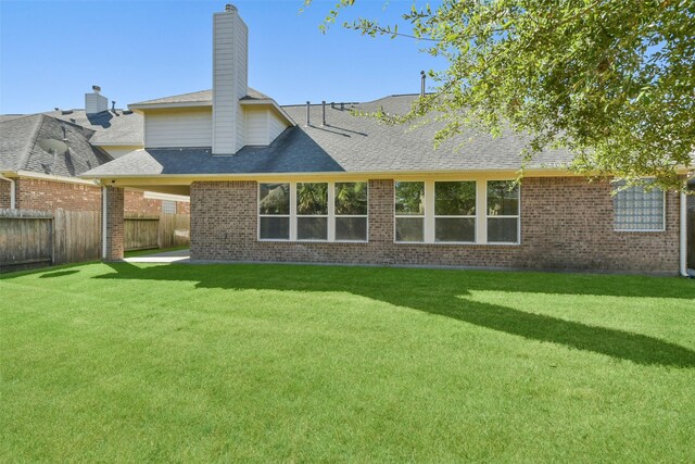 rear view of property featuring a patio area and a yard