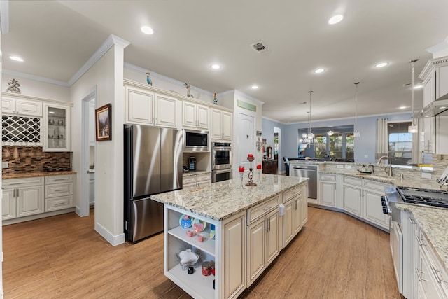 kitchen featuring a center island, light wood-type flooring, hanging light fixtures, and appliances with stainless steel finishes