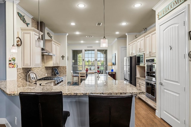 kitchen featuring kitchen peninsula, light hardwood / wood-style flooring, hanging light fixtures, and ornamental molding