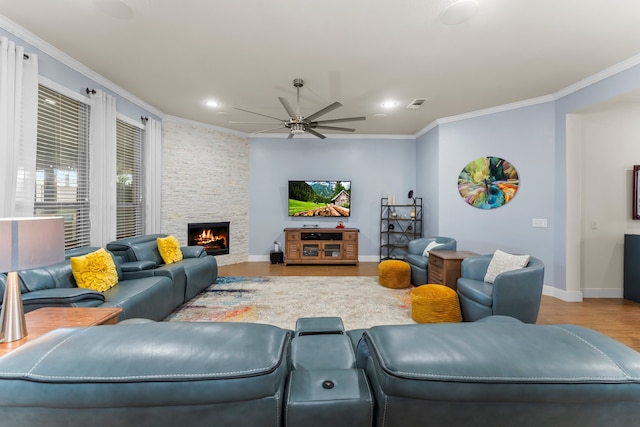 living room with ceiling fan, light hardwood / wood-style floors, crown molding, and a fireplace