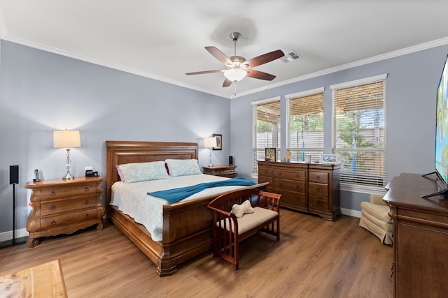 bedroom with light wood-type flooring, ceiling fan, and crown molding