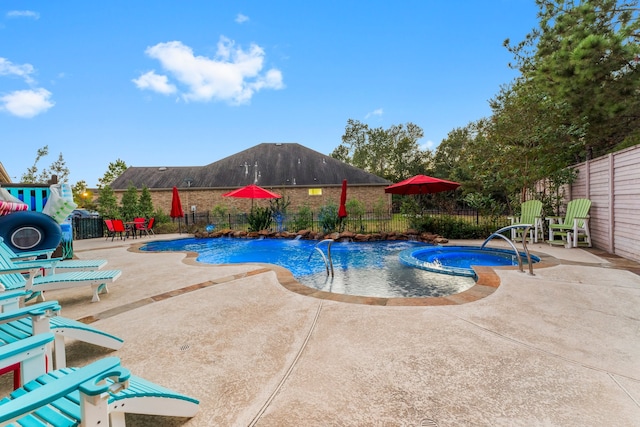 view of pool with an in ground hot tub, pool water feature, and a patio