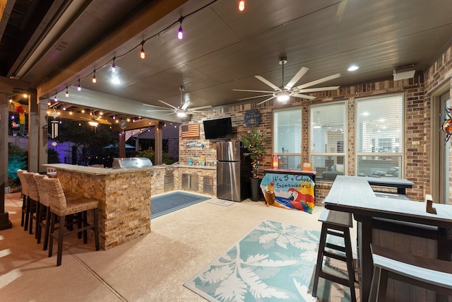 view of patio / terrace featuring an outdoor kitchen, an outdoor bar, ceiling fan, and grilling area