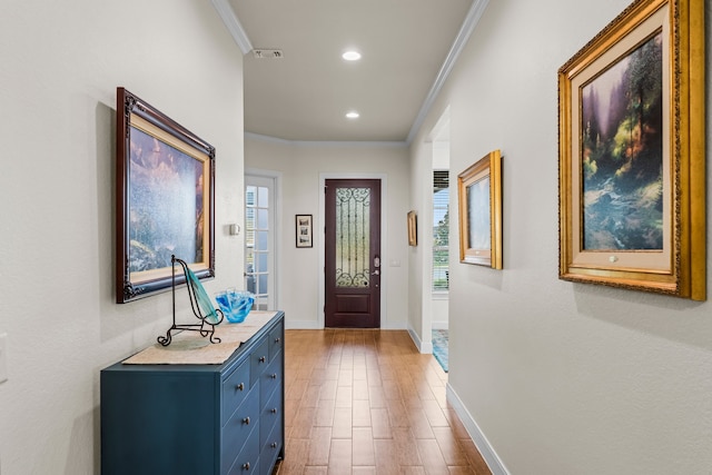 foyer with hardwood / wood-style flooring, plenty of natural light, and crown molding