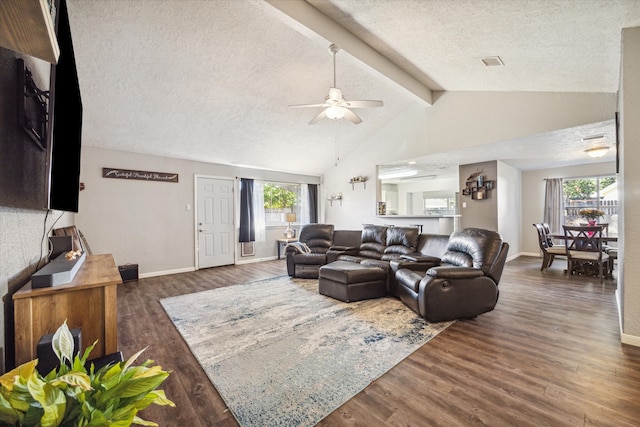 living room featuring vaulted ceiling with beams, a textured ceiling, dark wood-type flooring, and ceiling fan