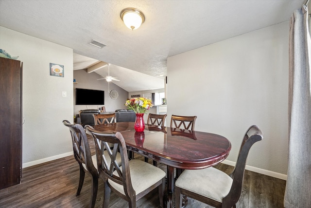 dining space with dark wood-type flooring, lofted ceiling with beams, a textured ceiling, and ceiling fan