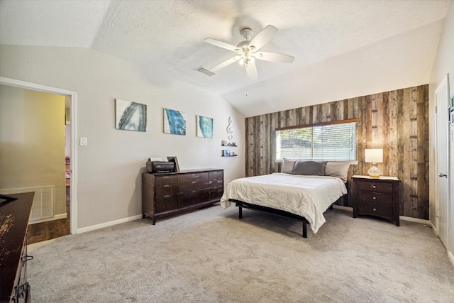 bedroom with ceiling fan, light carpet, a textured ceiling, and lofted ceiling