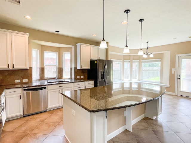 kitchen featuring a center island, a healthy amount of sunlight, stainless steel appliances, and tasteful backsplash