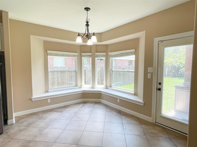 unfurnished dining area featuring a notable chandelier, light tile patterned floors, and plenty of natural light