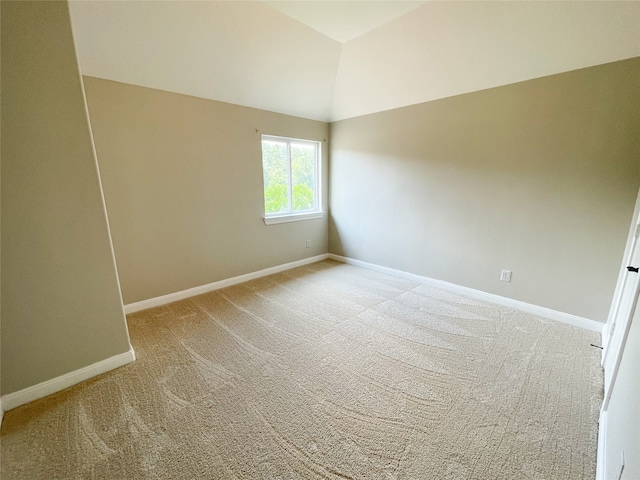 unfurnished room featuring light colored carpet and vaulted ceiling