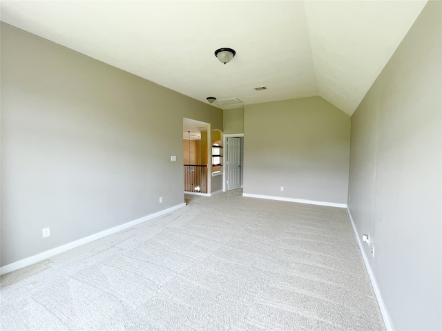 empty room featuring lofted ceiling and carpet flooring