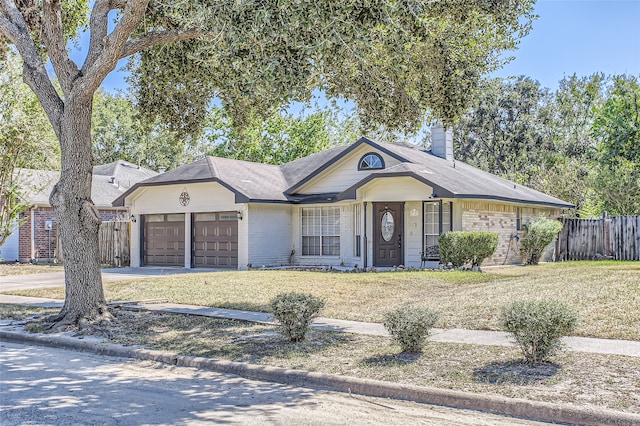 ranch-style home featuring a front lawn and a garage