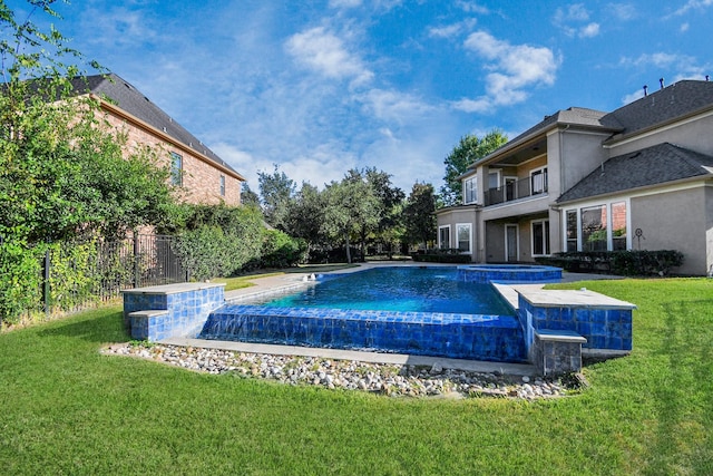 view of swimming pool with a lawn and a pool with connected hot tub