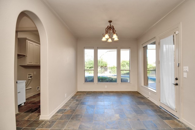 unfurnished dining area featuring ornamental molding, stone finish flooring, and a wealth of natural light