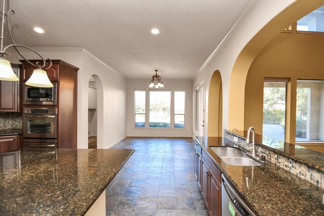 23011 Little Harbor Way, Katy, TX 77494 - kitchen with crown molding, stone tile floors, arched walkways, a sink, and appliances with stainless steel finishes