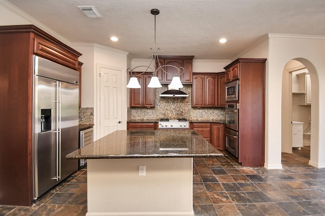 kitchen with built in appliances, arched walkways, beverage cooler, a kitchen island, and visible vents