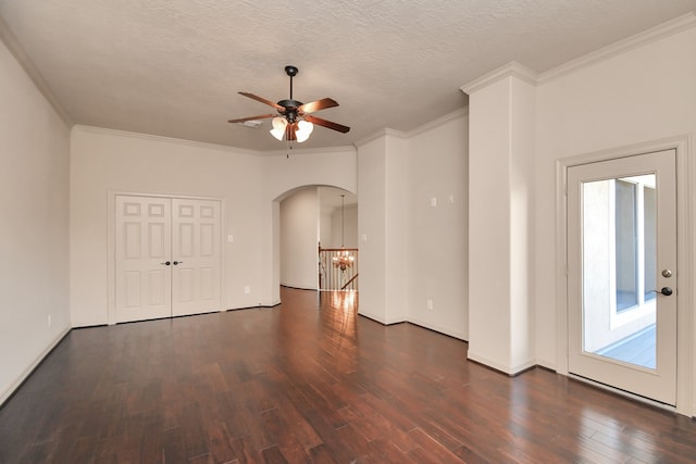 spare room with dark wood-type flooring, crown molding, and ceiling fan with notable chandelier