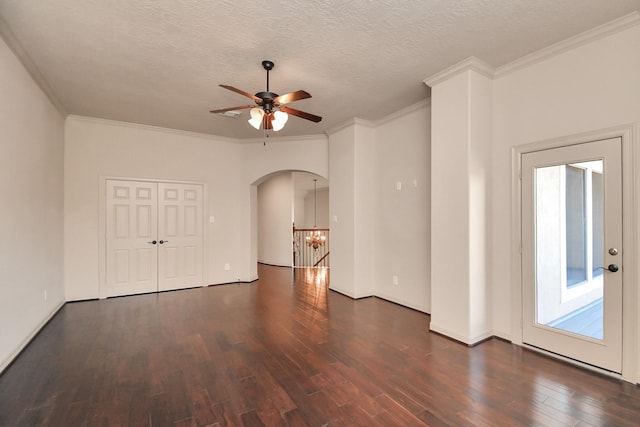 interior space featuring ceiling fan, arched walkways, baseboards, wood finished floors, and ornamental molding