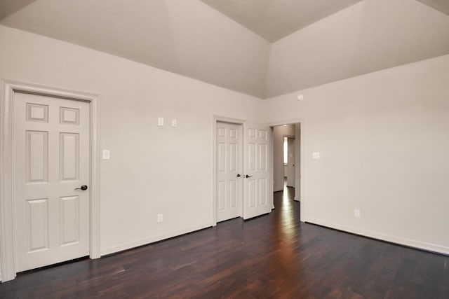 unfurnished bedroom with high vaulted ceiling, baseboards, and dark wood-style flooring