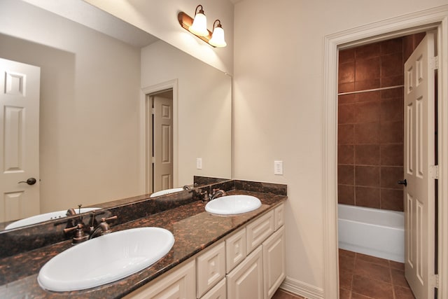 bathroom featuring vanity, tiled shower / bath combo, and tile patterned flooring