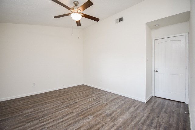 empty room with ceiling fan and dark hardwood / wood-style flooring