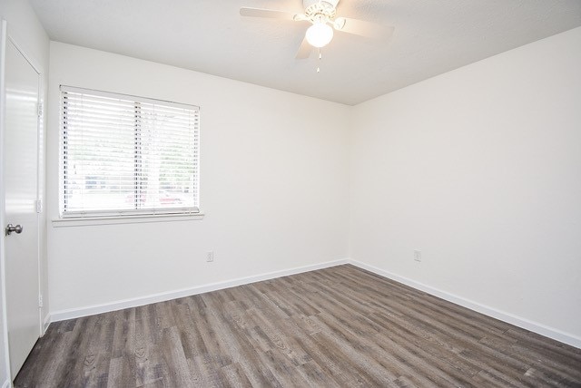 unfurnished room featuring ceiling fan and dark hardwood / wood-style flooring