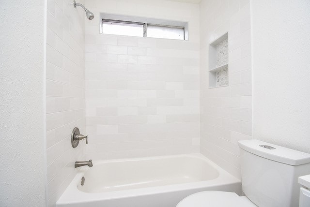 full bathroom featuring tiled shower / bath, vanity, and toilet