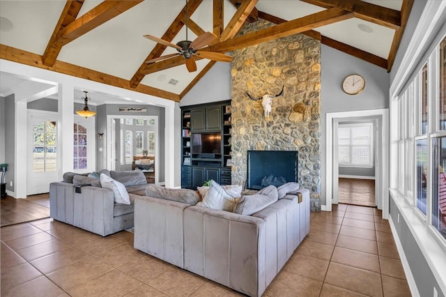 living room featuring beam ceiling, light tile patterned floors, a fireplace, high vaulted ceiling, and ceiling fan