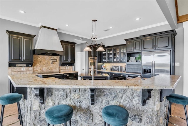 kitchen with decorative backsplash, a breakfast bar area, stainless steel appliances, a large island, and premium range hood