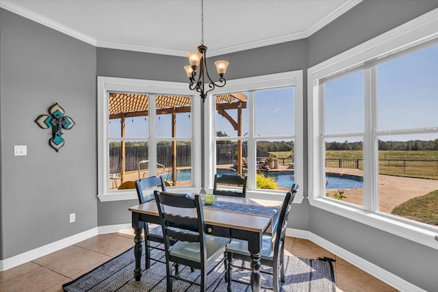 dining area featuring crown molding, a chandelier, and tile patterned flooring