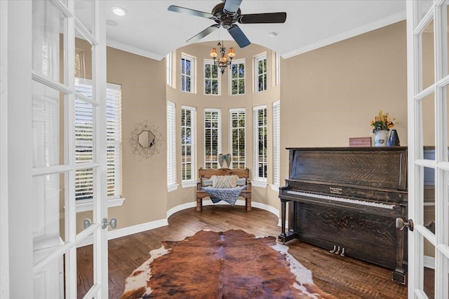 living area featuring french doors, a notable chandelier, wood-type flooring, and ornamental molding