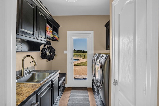 washroom with washing machine and dryer, light tile patterned flooring, cabinets, and sink