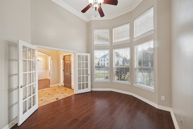 empty room with french doors, ornamental molding, hardwood / wood-style flooring, and ceiling fan