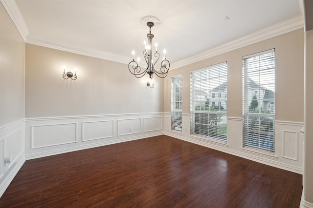 empty room featuring ornamental molding, dark wood-type flooring, and a notable chandelier